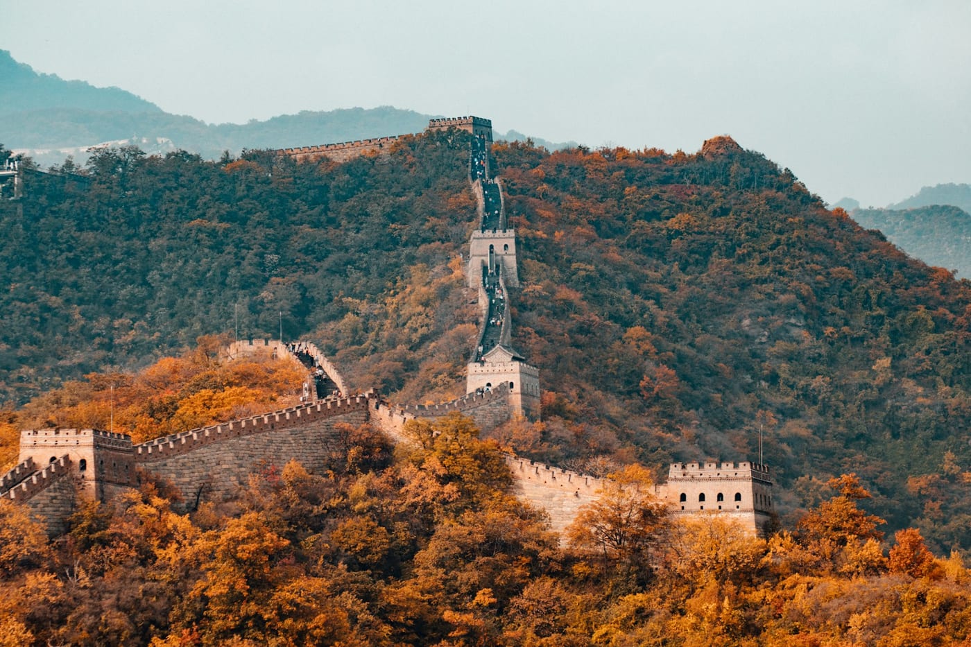 A cable car climbing a section of the Great Wall above forest