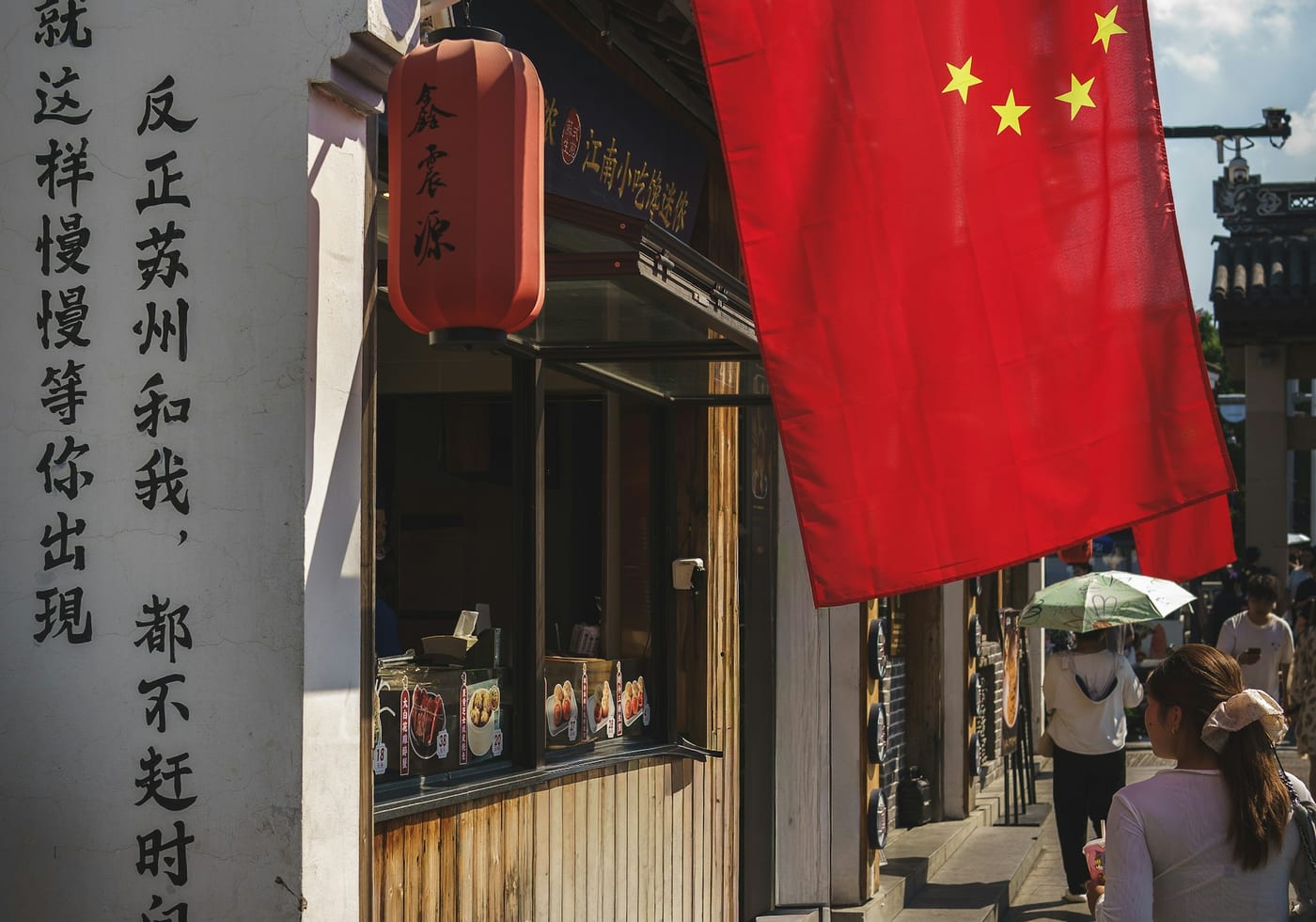 A quieter older street in Suzhou with shopfronts and pedestrians