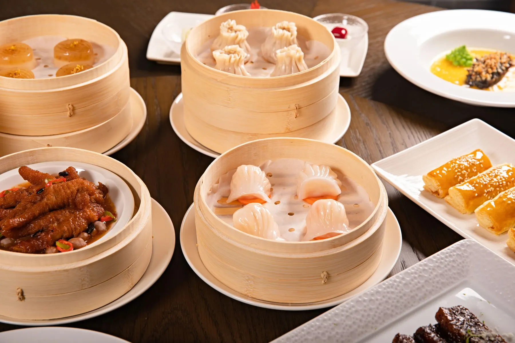 Bamboo steamers of har gow, siu mai and chicken feet on a Cantonese tea house table